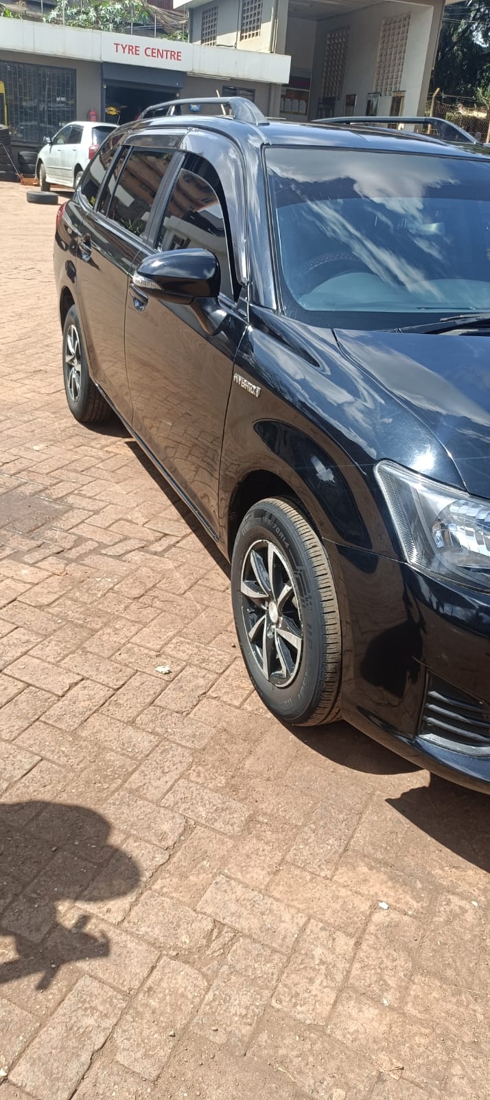 Black Toyota Corolla Fielder side profile on alloy wheels